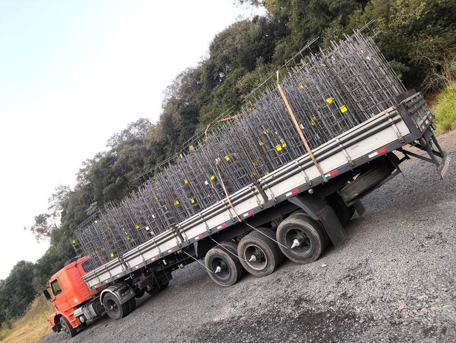 Carreta carregada com estacas armadas